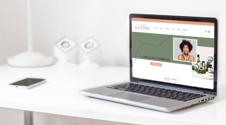 Laptop displaying a sleek Shopify store homepage on a minimalist desk, highlighting modern e-commerce design and branding potential