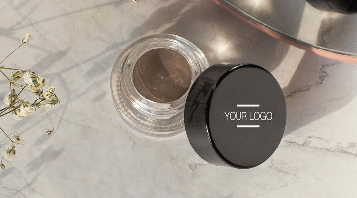 Close-up of a customizable beauty product jar with a sleek black lid on a marble surface, highlighting premium design and quality for cosmetics branding