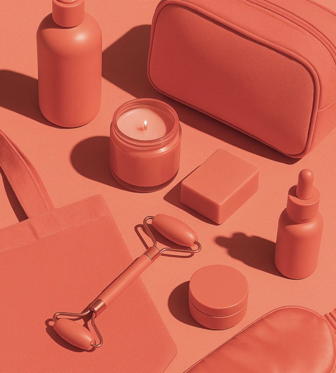 Flatlay of coral-colored self-care items including a candle, face roller, dropper bottle, bar soap, pouch, and tote bag—all styled monochromatically on a coral background.