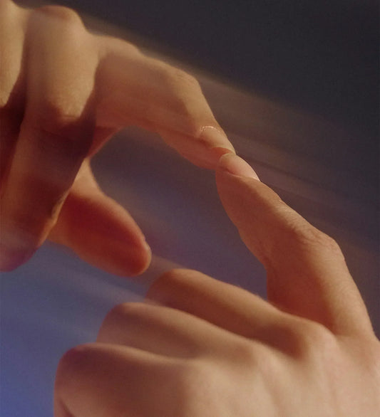 Close-up of two hands reaching toward each other with fingertips about to touch.