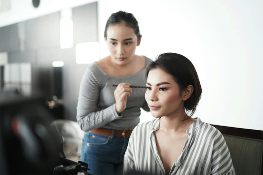 Makeup artist applying finishing touches to a client, symbolizing opportunities for independent professionals to expand revenue streams in the beauty industry