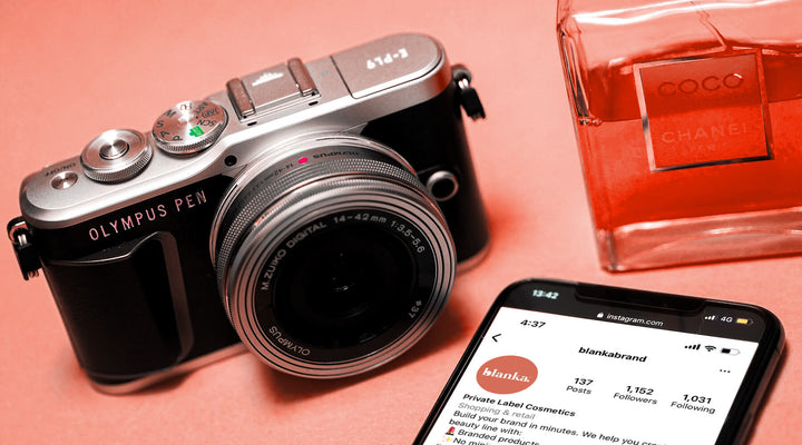  Stylish composition featuring an Olympus camera, Chanel perfume, and a phone displaying Blanka's Instagram page, perfect for highlighting influencer marketing trends and luxury branding