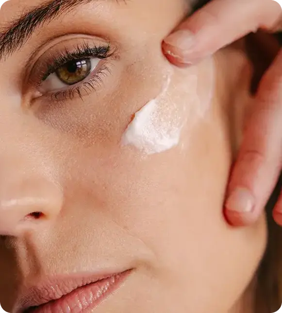 Close-up of a person applying cream to their face