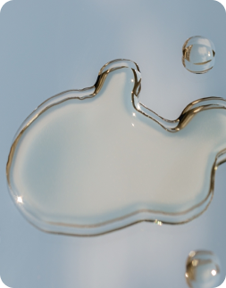 Close-up of a clear liquid with a small bubble on a light blue background