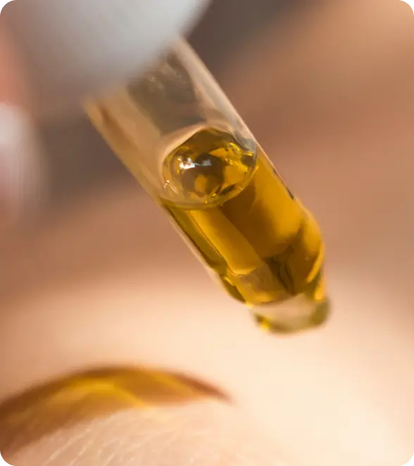 Close-up of a vial with a yellow liquid on a blurred background