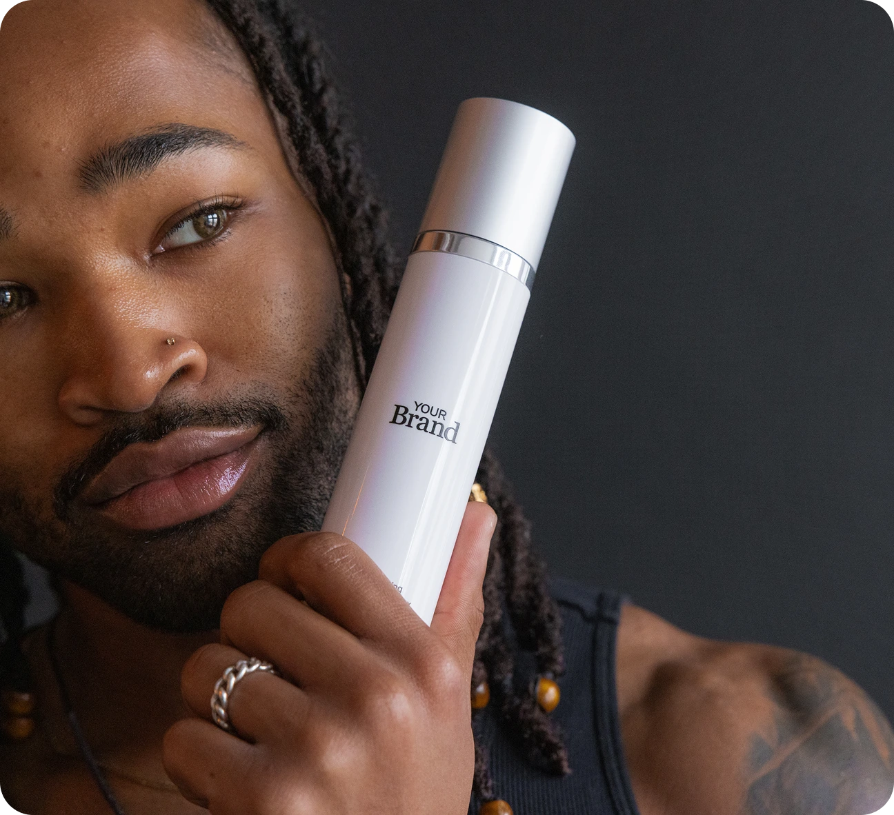 Black barber examining custom branded hair product in his barbershop