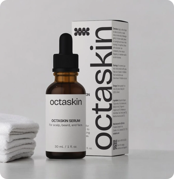 Octaskin serum in an amber glass dropper bottle with a black cap, shown next to its white product box and a folded stack of white towels on a light gray background.