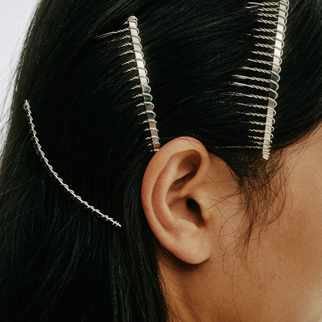 Female hair pulled back with clips.