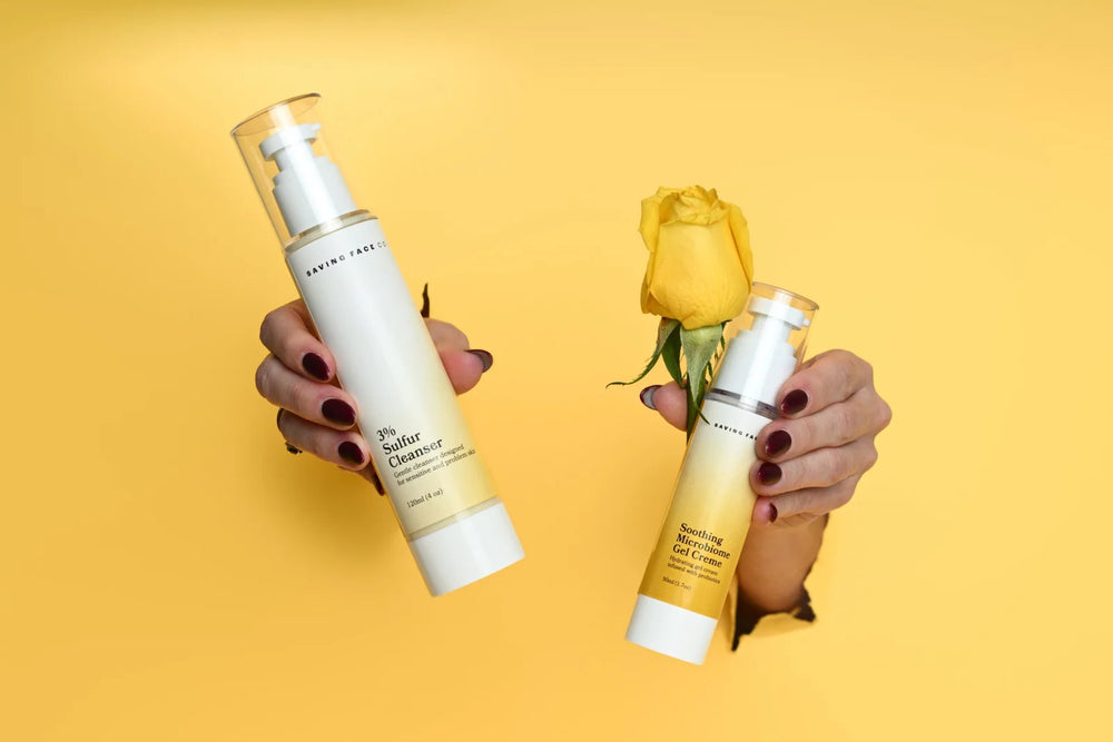 Two skincare bottles held by hands against a yellow background
