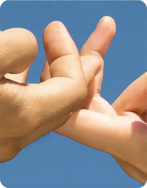 Two fingers interlocking fingers against a blue background.webp