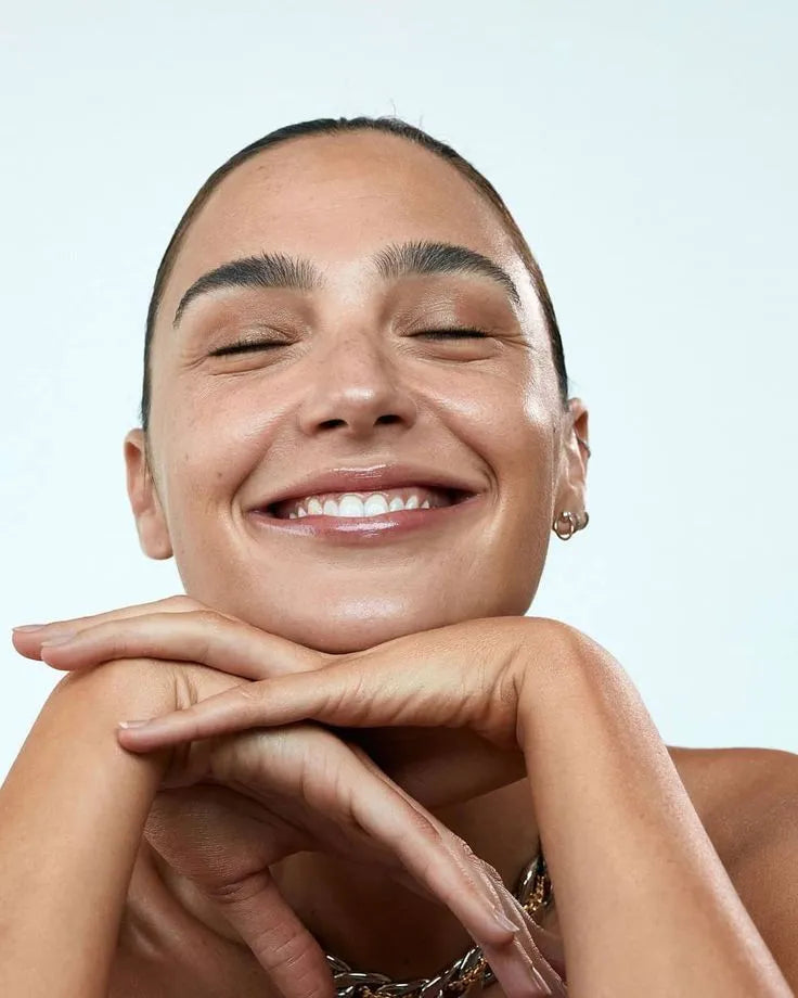 Woman with a radiant smile against a light blue background
