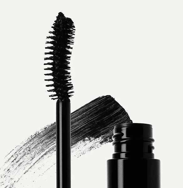 Black mascara with brush and cap on a white background