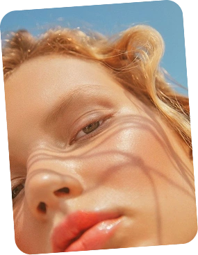 Close-up of a person with blonde hair against a blue sky