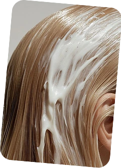 Hairstylist applying custom branded hair treatment serum to client's blonde hair