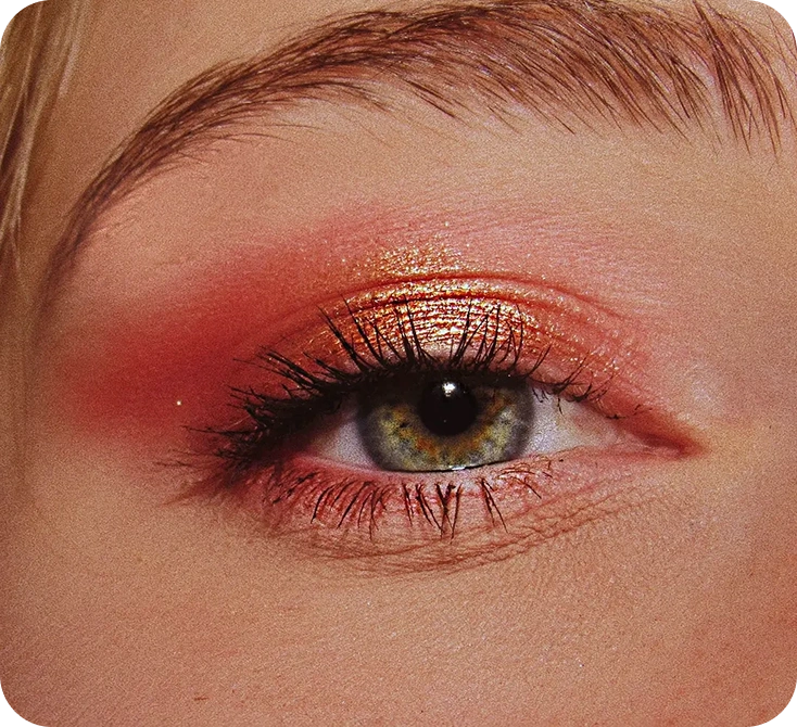 Close-up of eye makeup showing bronze eyeshadow and dramatic lashes