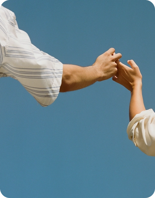 Hands holding against blue sky