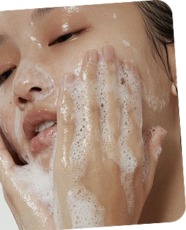 Person applying soap to their face with a close-up view.